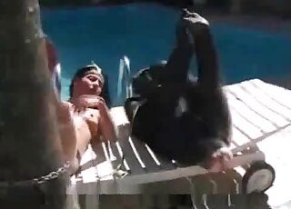 Naughty brunette stuffs a dildo in her pussy next to a monkey